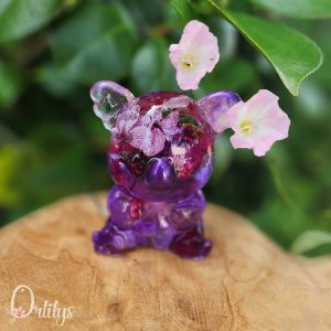 Un koala rempli de fleurs violettes et blanches