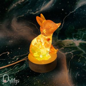 Un renard avec des fleurs oranges, la veilleuse est allumée